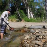 Catchment Solutions team member clears debris from the Forbes Road fishway.