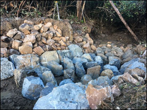 Commencement of nature-like fishway construction, ridge rocks and wall rocks in place of the lower ridges, and scour protection visible on the bank.